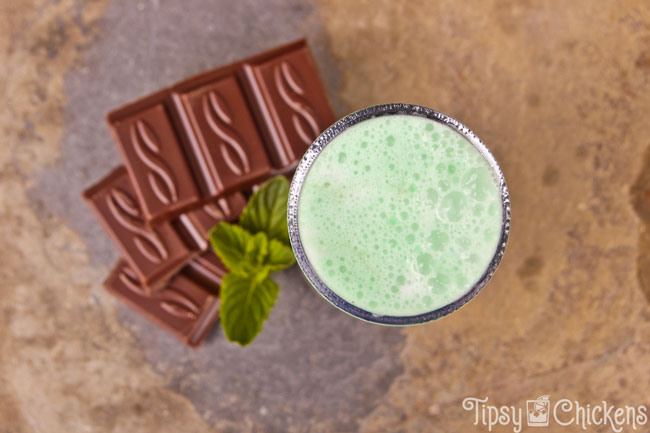 top view of a grasshopper shot with chocolate pieces and mnit leaves on a natural tile background