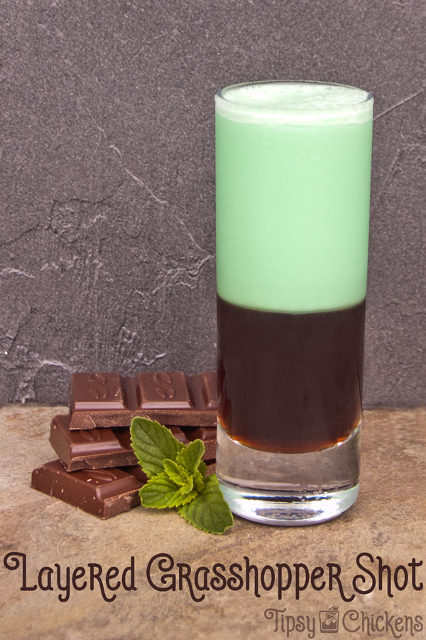 dshooter glass filled with dark creme de cacao with green creme de menthe and cream shaken together and layered over top with chocolate and fresh mint garnish