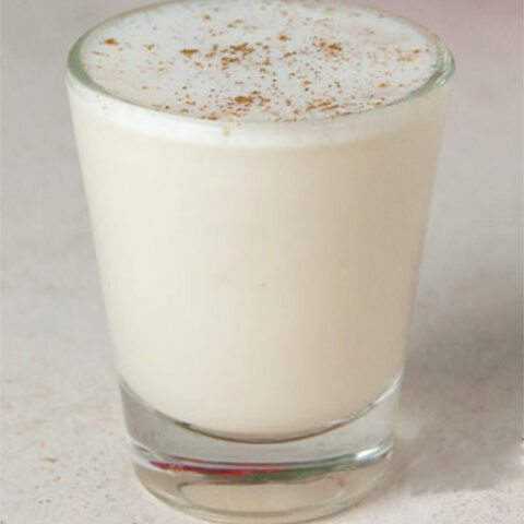single shot glass filled with RumChata and vanilla schnapps on a white tile surface