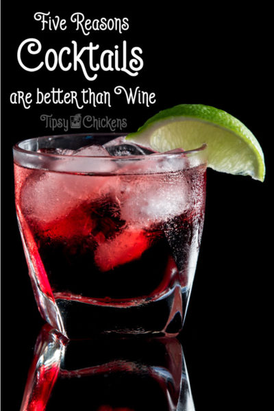 Cranberry and lime cocktail on the rocks in a rocks glass against a black background