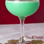 mint and Irish cream Christmas cocktail in a coupe glass on a golden snowflake