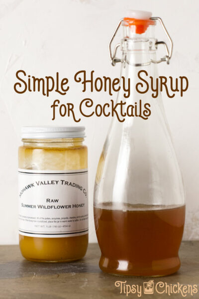 glass bottle filled with honey syrup next to a glass jar of honey