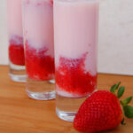 three tall shooter glasses with strawberry puree, cake vodka and tequila rose