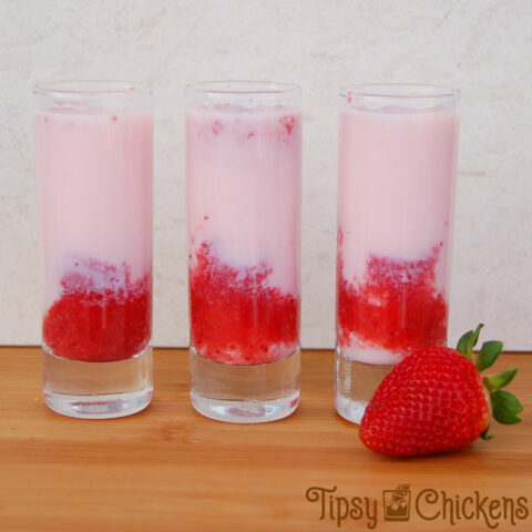 three tall shooter glasses with strawberry puree, cake vodka and tequila rose