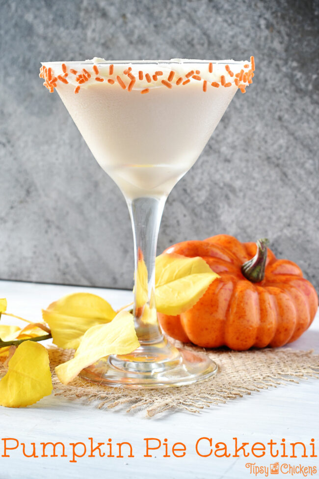 pumpkin pie cocktail in a martini glass with a frosting & sprinkle decorated rim